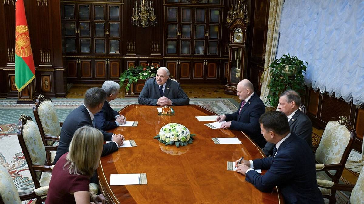 Grupa osób siedzących przy stole w sali konferencyjnej.