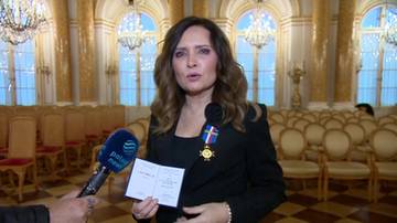 Agnieszka Gozdyra odbiera Krzyż NSZZ Policjantów, trzymając dokument i medal na wstędze.
