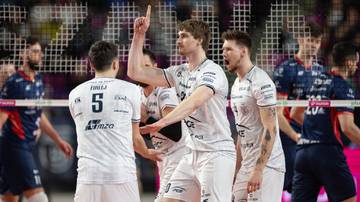 Siatkarze PGE Projekt Warszawa w białych strojach świętują zdobyty punkt.