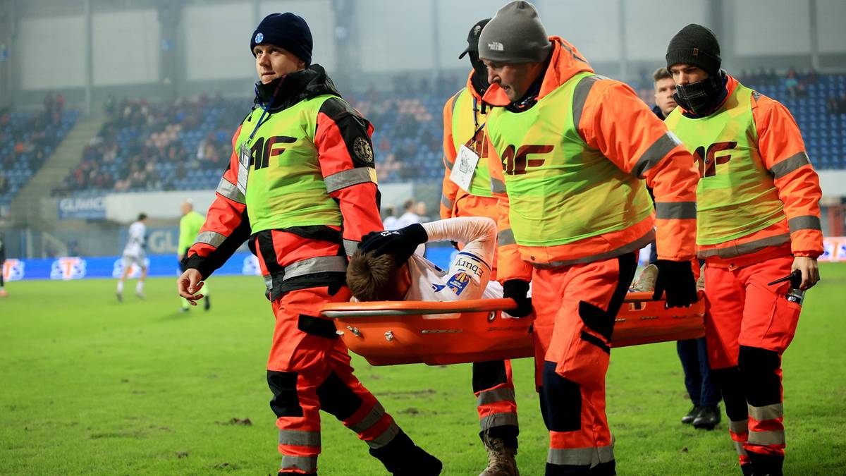 Ratownicy medyczni niosą zawodnika na noszach.