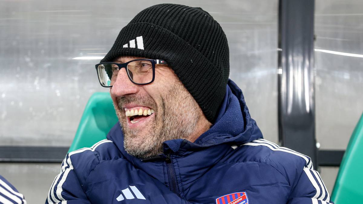 Marek Papszun, trener Rakowa Częstochowa, w czapce i okularach, uśmiecha się.