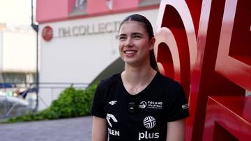 Maja Koput, siatkarka w czarnej koszulce z logo "POLAND VOLLEYBALL", uśmiechnięta na zewnątrz.