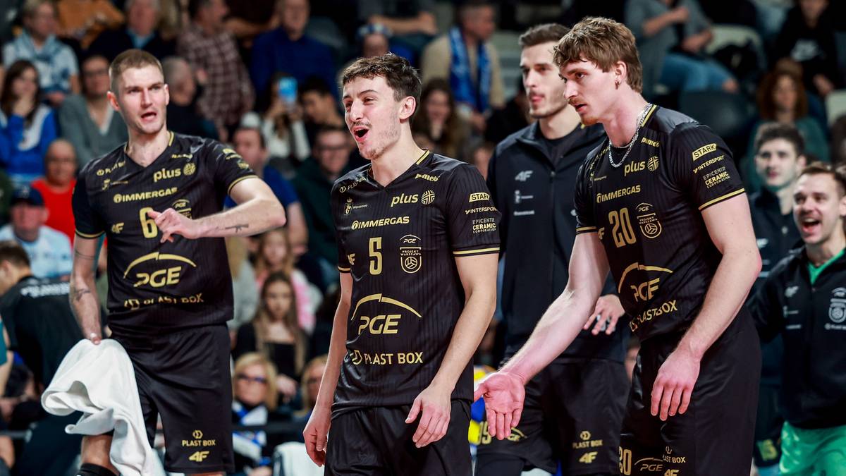 Siatkarze PGE Projektu Warszawa w czarnych strojach z żółtymi akcentami podczas meczu.