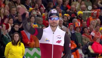 Zawodnik w stroju do łyżwiarstwa szybkiego pozdrawia publiczność.