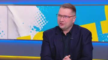 Przemysław Czarnek w marynarce i okularach, siedzi w studiu telewizyjnym.