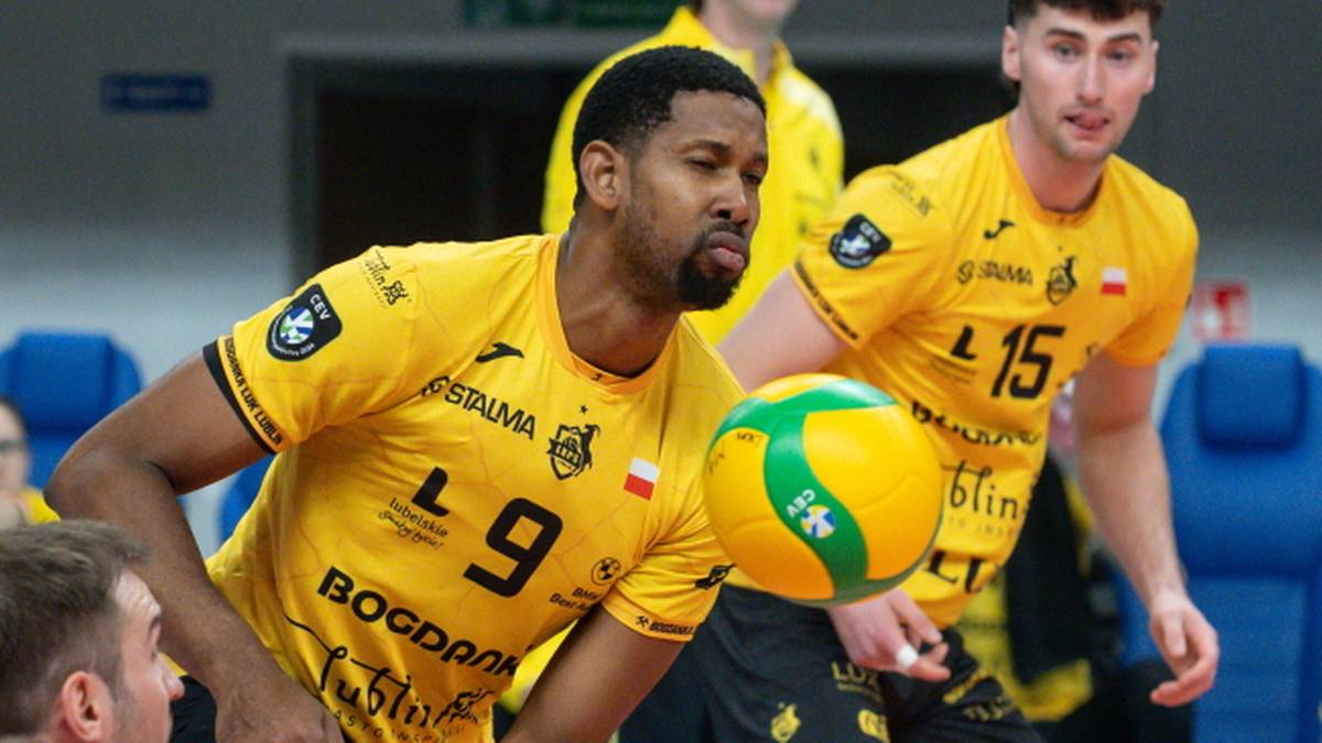 Dwóch siatkarzy w żółtych koszulkach z numerami 9 i 15, jeden z nich odbija piłkę.