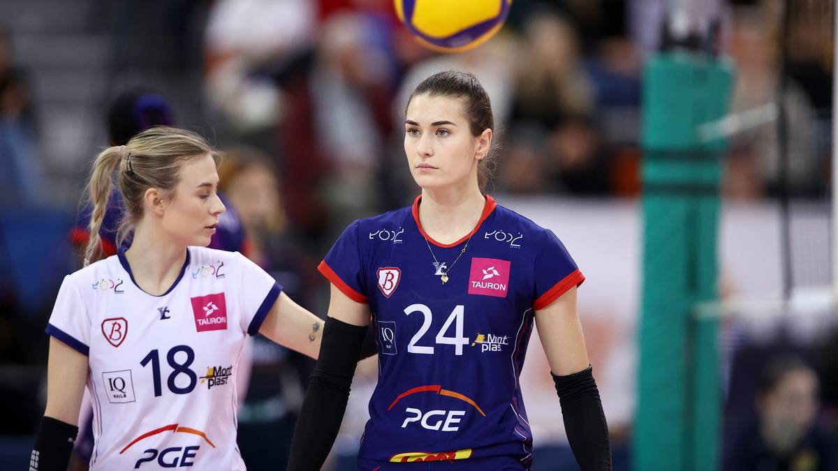 Dwie siatkarki na boisku, jedna w białej koszulce z numerem 18, druga w granatowej z numerem 24.