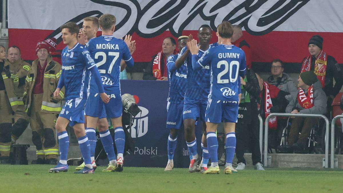 Piłkarze Lecha Poznań w niebieskich strojach świętują na boisku piłkarskim.