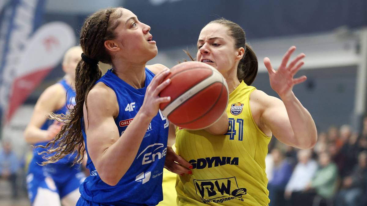 Koszykarka w niebieskiej koszulce z numerem 5 prowadzi piłkę podczas meczu.