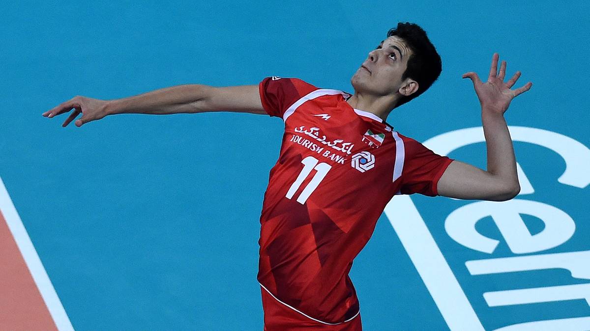 Siatkarz w czerwonej koszulce z numerem 11 podczas akcji na boisku.