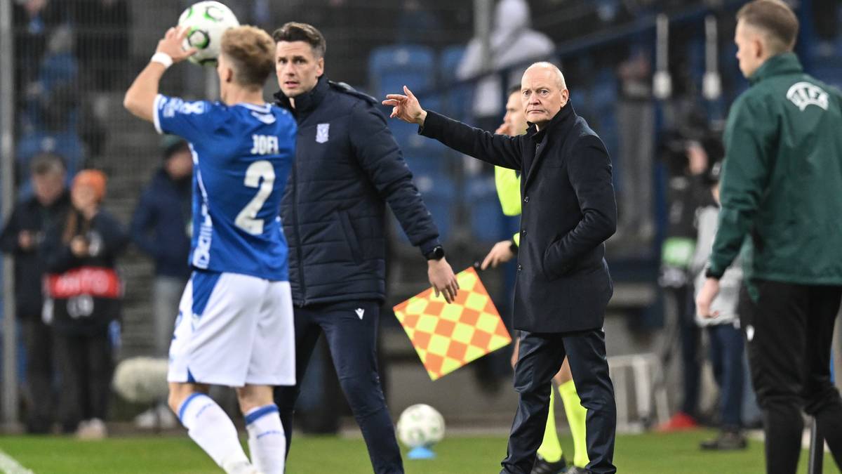 Trener Lecha Poznań daje wskazówki zawodnikowi podczas meczu piłki nożnej.