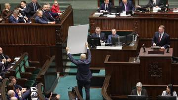 Poseł PiS Dariusz Matecki trzyma w Sejmie dużą fotografię z premierem Donaldem Tuskiem i Kamilą L.