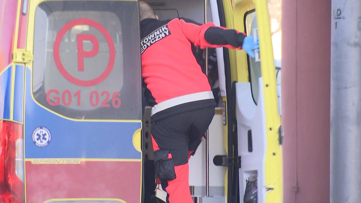 Ratownik medyczny wchodzi do karetki pogotowia w trudnych warunkach atmosferycznych.