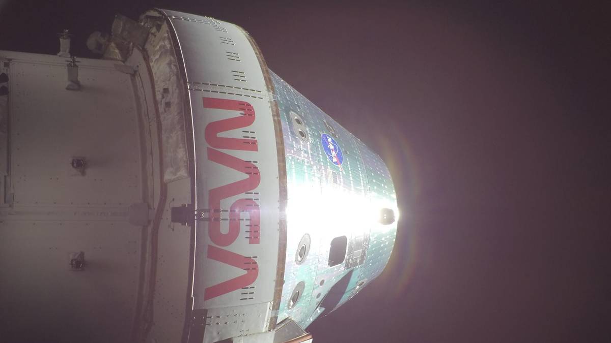 Zbliżenie na kapsułę statku kosmicznego Orion z widocznym logo NASA, podczas powrotu na Ziemię.