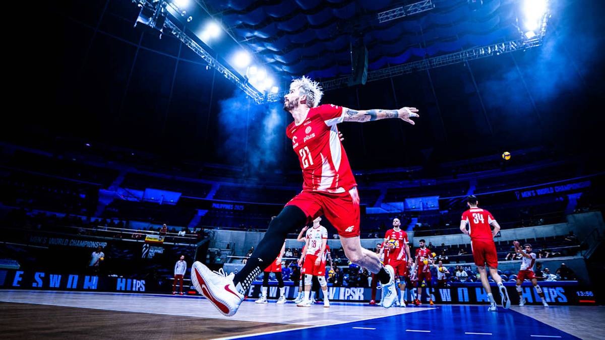 Siatkarz w czerwonej koszulce wyskakuje do zagrania piłki w trakcie meczu.