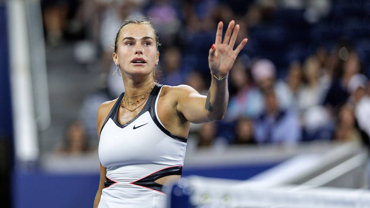 Aryna Sabalenka, tenisistka, podnosi rękę do góry, machając do widowni.