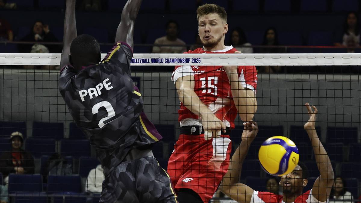 Gracz w czarnej koszulce z numerem 2 i napisem PAPE próbuje zablokować atak gracza w czerwonej koszulce z numerem 15. Piłka jest w powietrzu w pobliżu siatki.