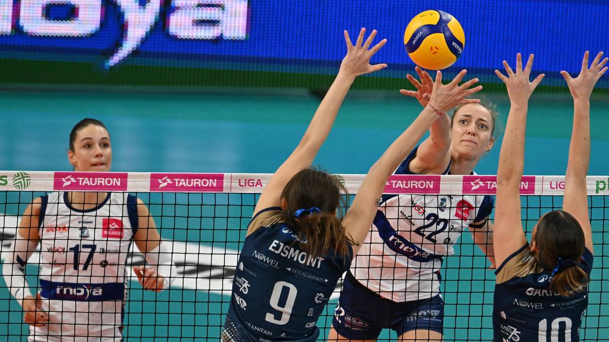 Siatkarki blokuja atak przeciwniczki w meczu siatk&oacute;wki