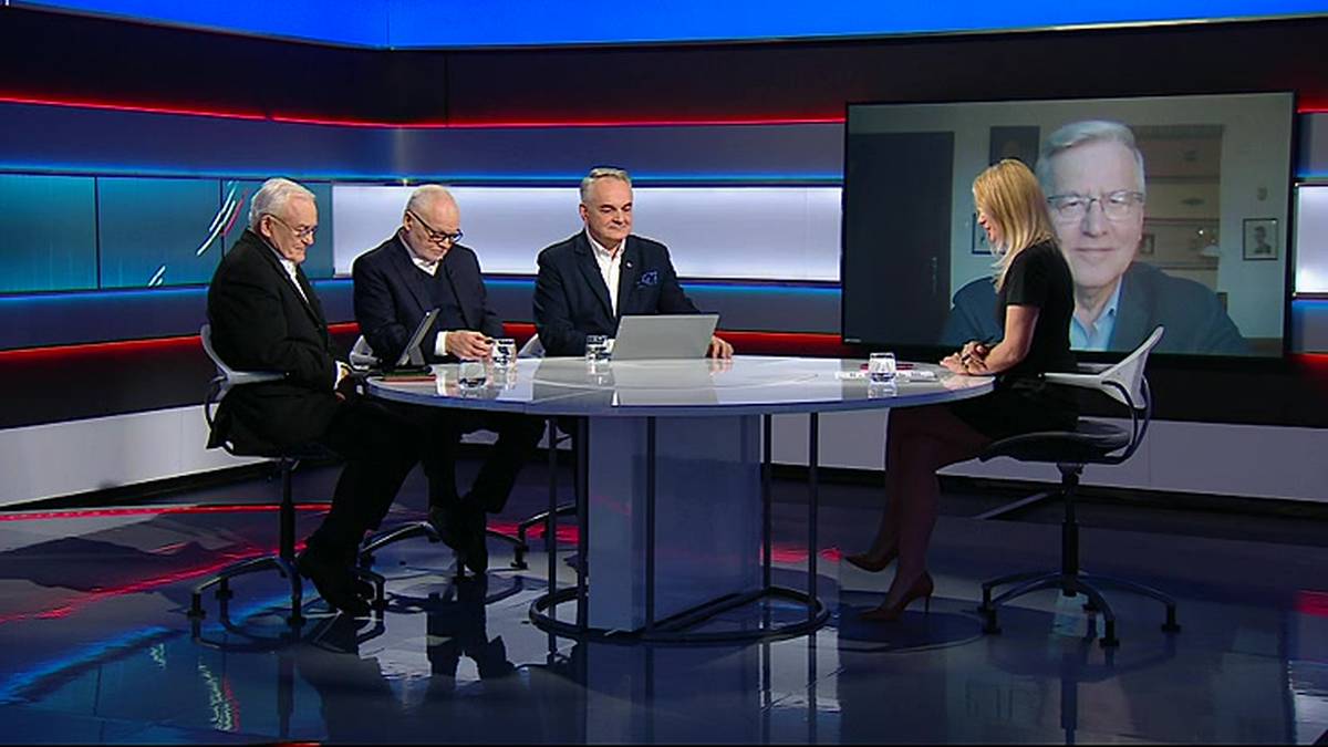 Cztery osoby biorą udział w dyskusji telewizyjnej, trzy siedzą przy stole w studiu, a jedna osoba jest widoczna na ekranie.