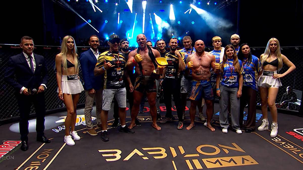 Grupa zawodników i zawodniczek MMA oraz osoby z ich otoczenia pozuje na scenie podczas gali Babilon MMA 59 w Międzyzdrojach.