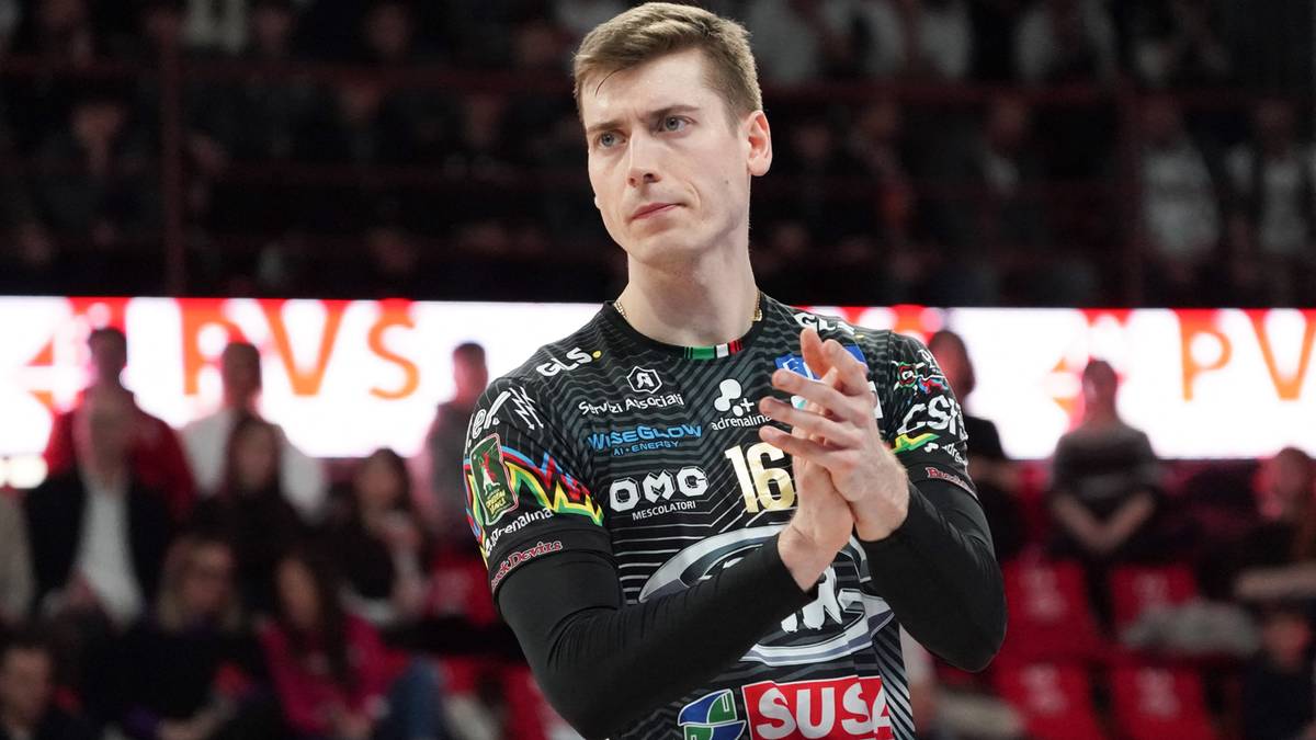 Siatkarz w koszulce z numerem 16, z dłońmi złożonymi przed sobą.