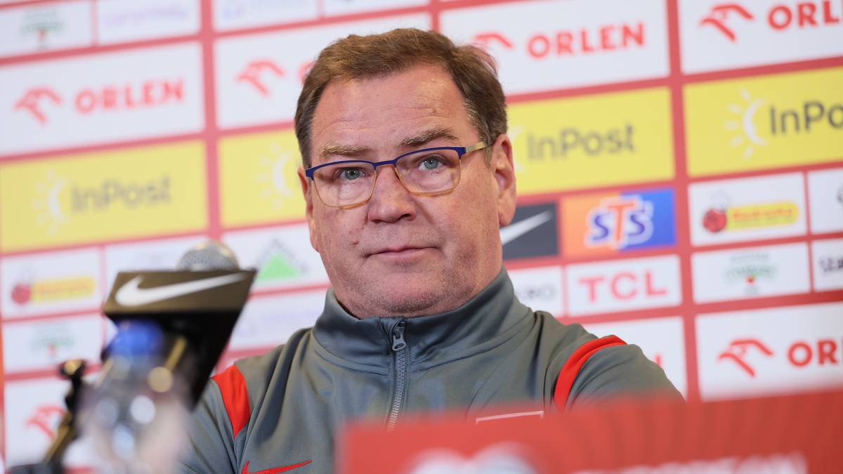 Jan Urban, trener reprezentacji Polski, siedzi przy stole podczas konferencji prasowej.