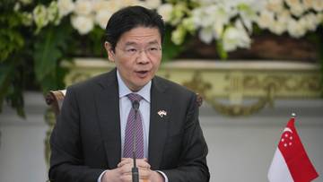 Lawrence Wong, premier Singapuru, w ciemnym garniturze i krawacie, przemawia podczas oficjalnego spotkania.
