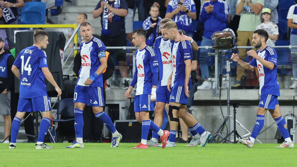 Drużyna Wisły Płock w niebiesko-białych strojach świętuje na boisku piłkarskim.