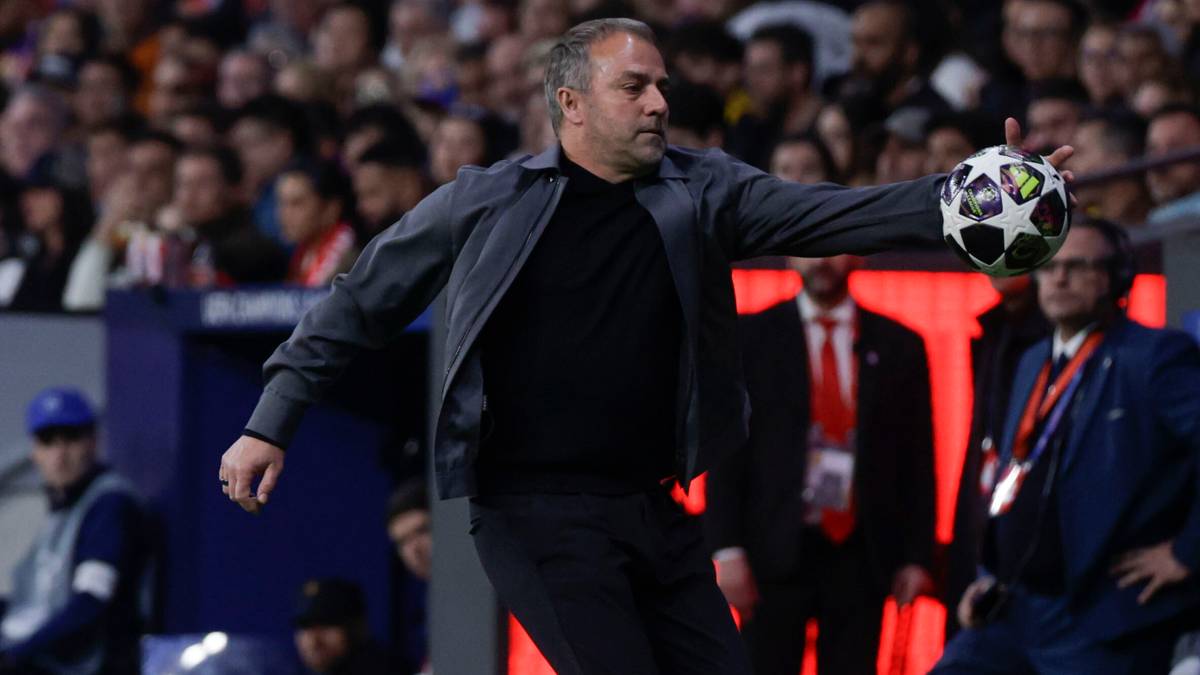 Hansi Flick, trener, trzymający piłkę nożną.