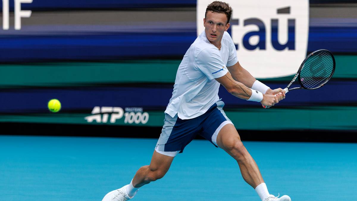 Tenisista wykonujący uderzenie forhendowe na korcie tenisowym, z widocznym logo ATP 1000 w tle.