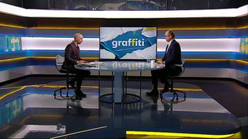 Dw&oacute;ch mężczyzn siedzi przy stole w studiu telewizyjnym. Na ekranie za nimi napis "graffiti".