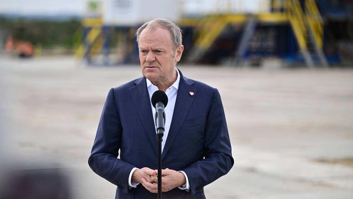 Premier Donald Tusk przemawia do mikrofonu.