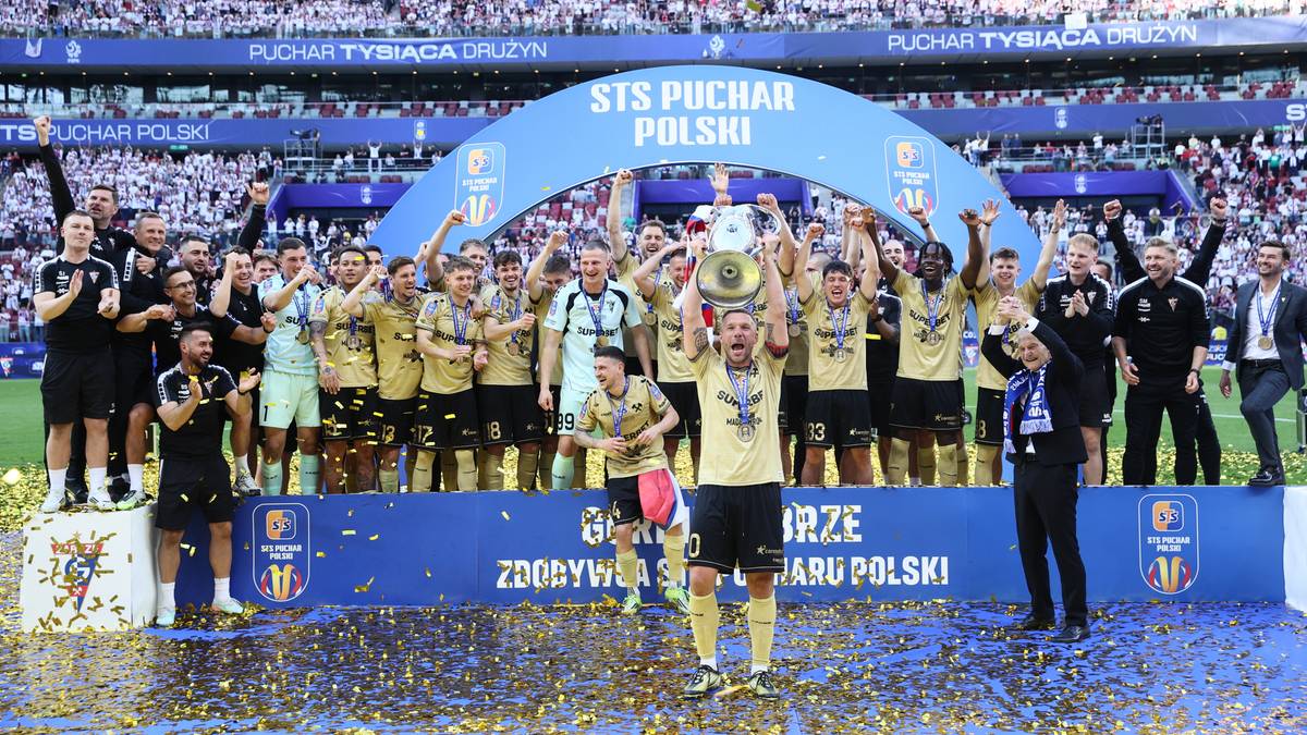Drużyna G&oacute;rnika Zabrze pozuje do zdjęcia z pucharem na stadionie PGE Narodowy, otoczona konfetti i kibicami.