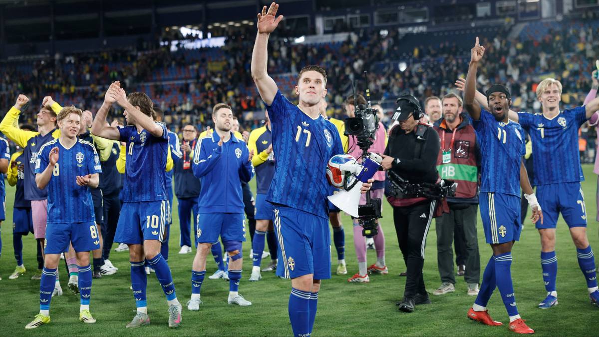 Piłkarze reprezentacji Polski w niebieskich strojach świętują zwycięstwo na boisku, machając do kibic&oacute;w.