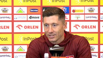 Portret Roberta Lewandowskiego podczas konferencji prasowej, z logotypami sponsorów w tle.