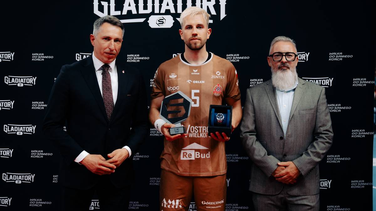 Trzech mężczyzn pozuje do zdjęcia na tle sceny z napisem "GLADIATORY". W środku stoi zawodnik z trofeum.