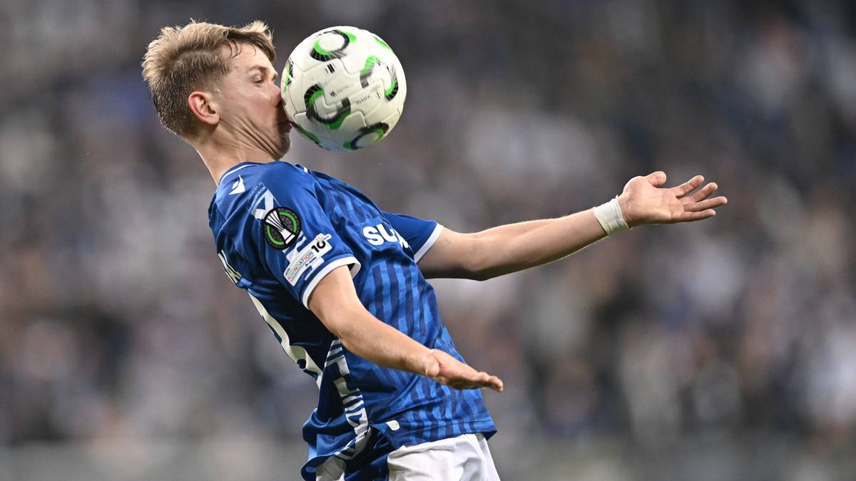 Piłkarz Lecha Poznań zagrywa piłkę głową.