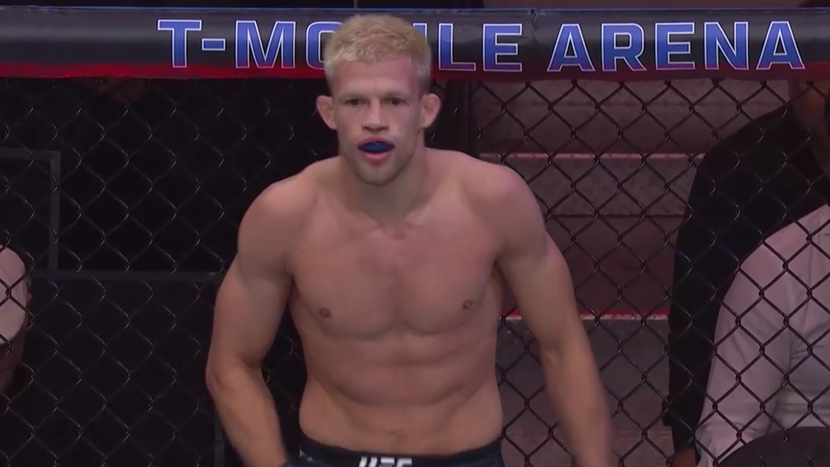 Zawodniczka MMA w klatce z ochraniaczem na zęby.