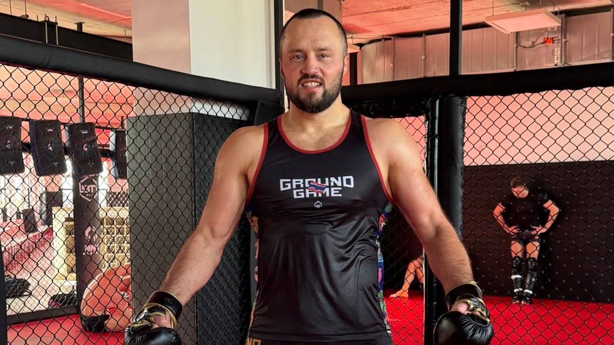 Tomasz Narkun stoi na ringu MMA w rękawicach bokserskich