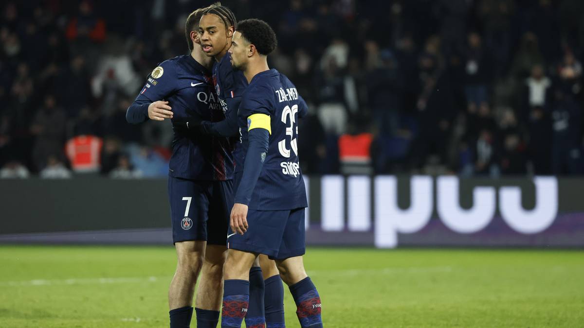 Dwóch piłkarzy PSG w granatowych strojach obejmuje się na boisku.