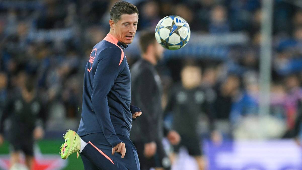 Robert Lewandowski podczas meczu piłki nożnej, kontrolujący piłkę nad głową.