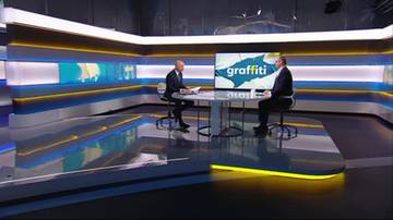 Dw&oacute;ch mężczyzn w garniturach podczas wywiadu w studiu telewizyjnym.