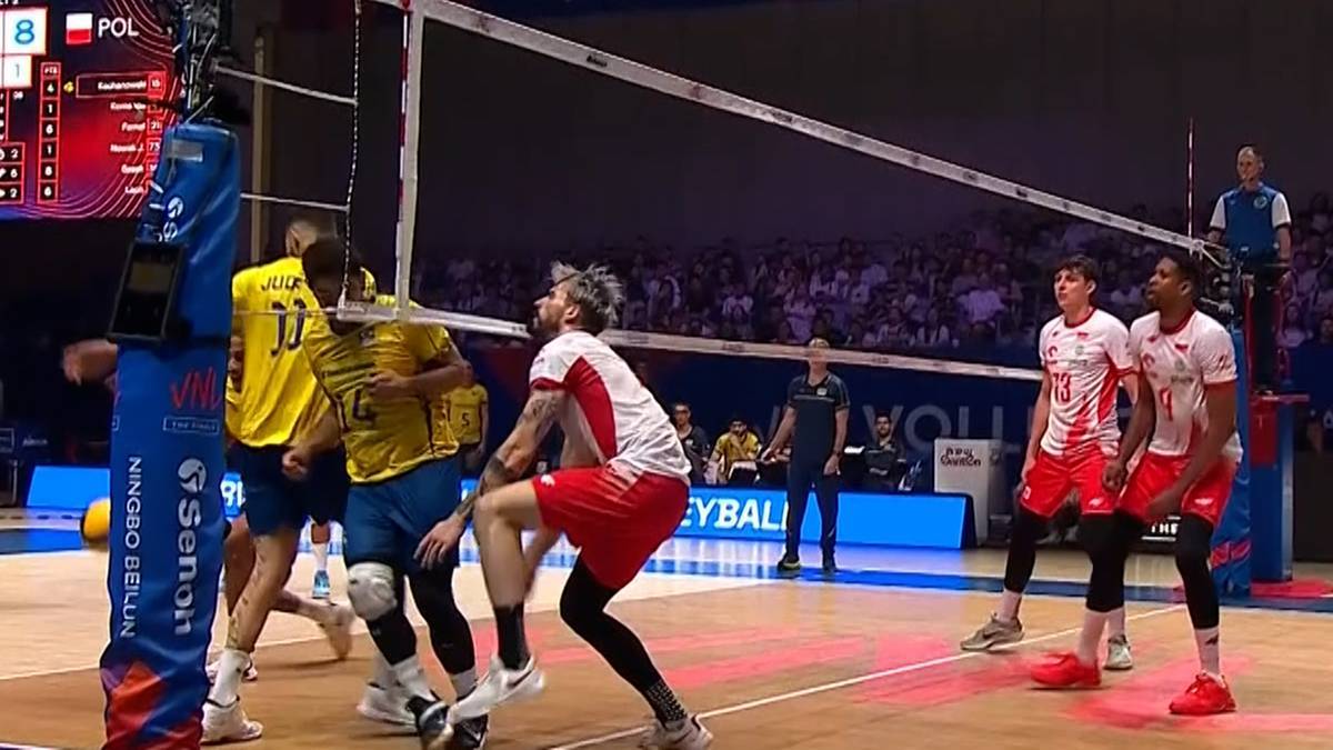 Siatkarze w białych i żółtych koszulkach podczas meczu siatkówki.