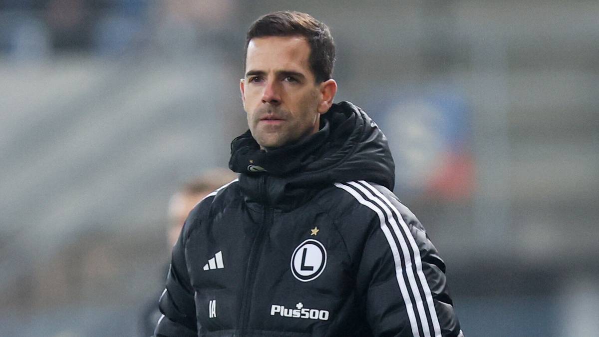 Trener Legii Warszawa w kurtce sportowej z logo klubu.