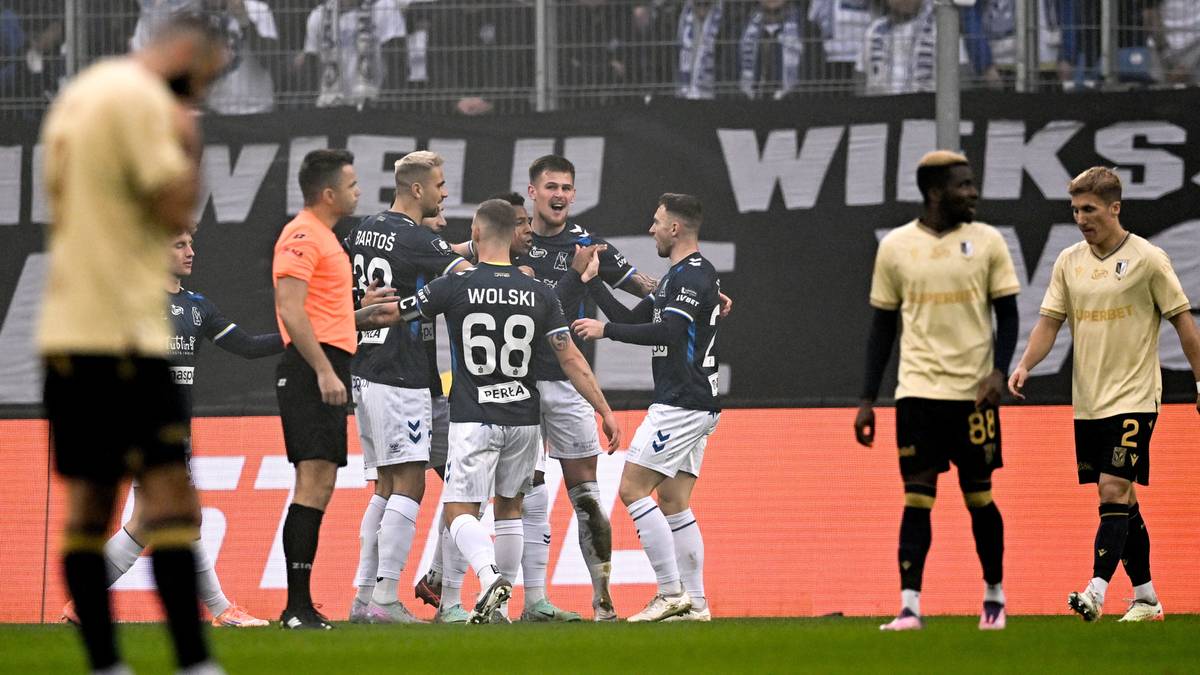 Piłkarze Motoru Lublin świętujący zdobycie bramki na boisku piłkarskim.