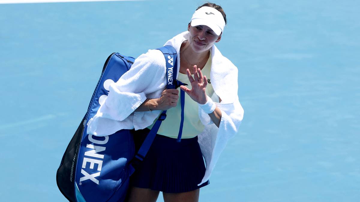 Tenisistka Magda Linette idzie po korcie z torbą sportową.