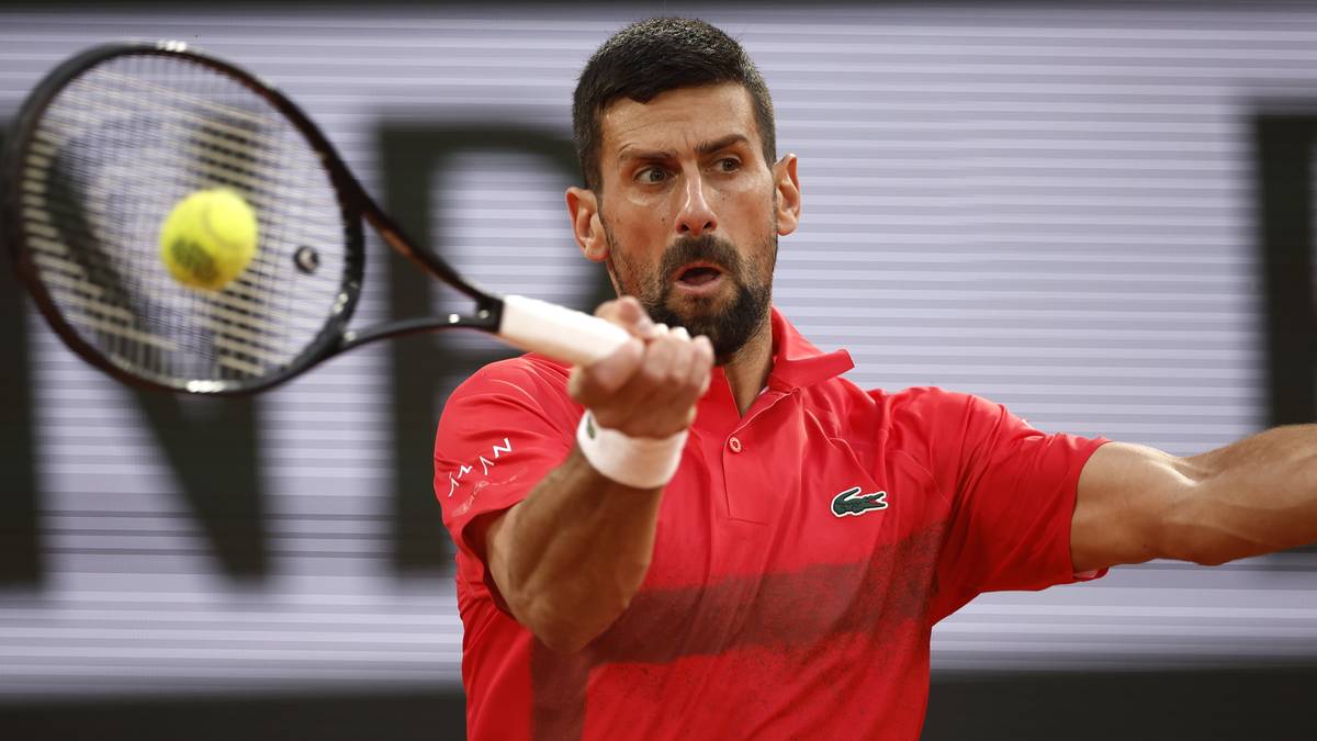 Tenisista Novak Djoković uderza piłkę rakietą podczas meczu.