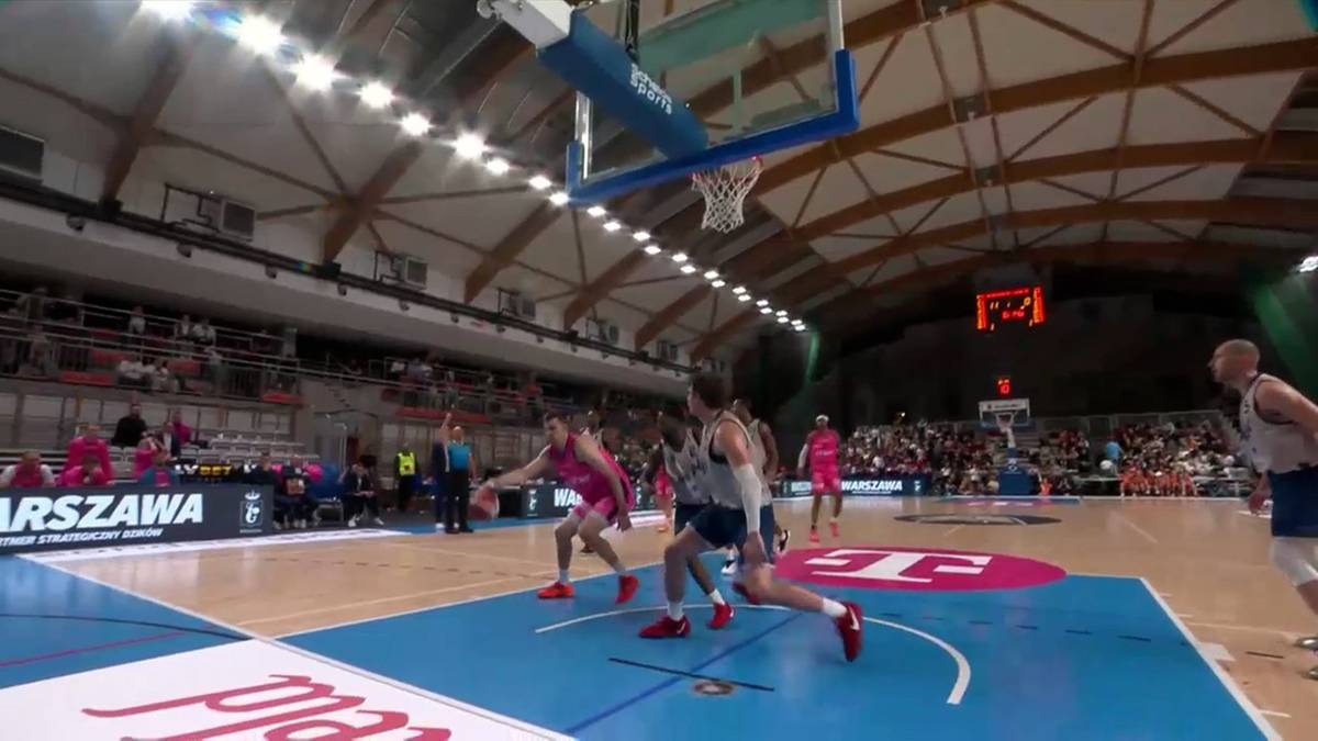 Zawodnicy drużyny w różowych strojach grają w koszykówkę przeciwko drużynie w niebieskich strojach.