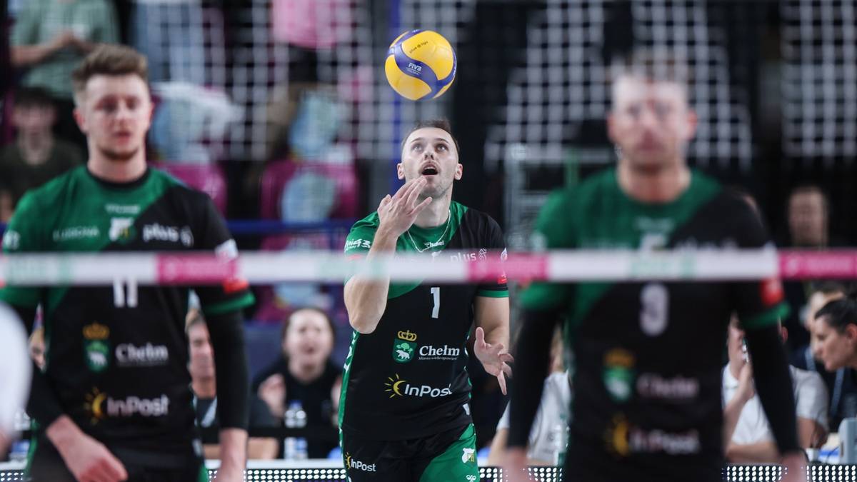 Siatkarze w zielono-czarnych strojach podczas meczu, jeden z nich przygotowuje się do zagrania piłki.