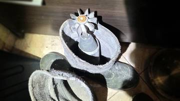 Fragment pocisku moździerzowego włożony do gumowych kaloszy.